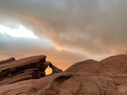 Sunrise at Arch Rock -- On the morning after a windstorm in Valley of fire state park, the sunrise takes on the same hue as the red Aztec Sandstone